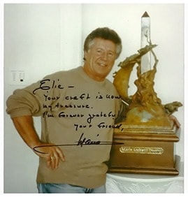 Archival photograph of Elie Hazak beside a commissioned trophy